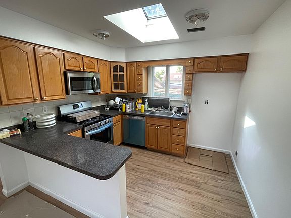 Kitchen with skylight, new microwave, new stove, new dishwasher.