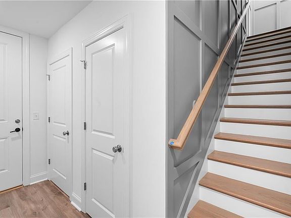 Hardwood flooring on hallways and stairs leading to main level living Images shown are from a decor