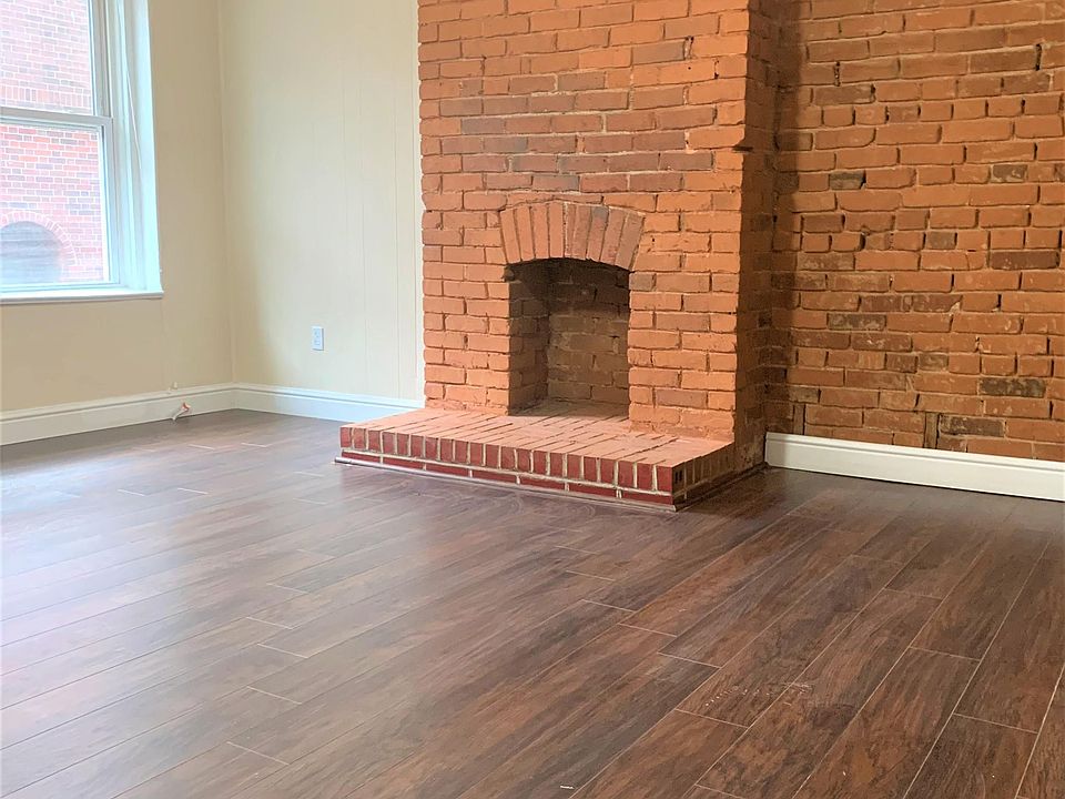 Living room with exposed brick accent wall and brand new flooring
