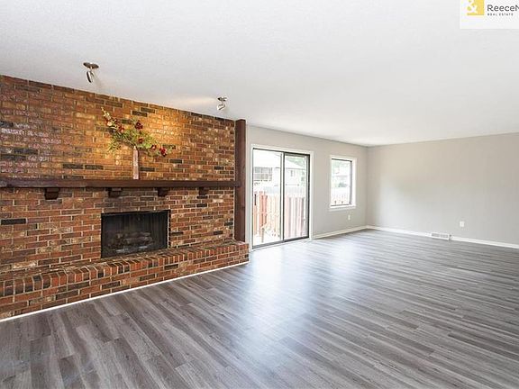 Open living/dining room with new flooring and fresh paint throughout.
