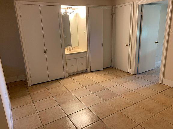 Bedroom with closets and vanity. Toilet and tub to right of closet.