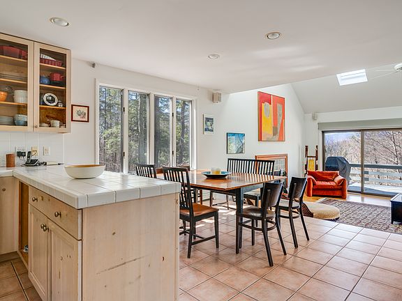 Open concept kitchen, dining area, and living room, all looking out to the generous deck.