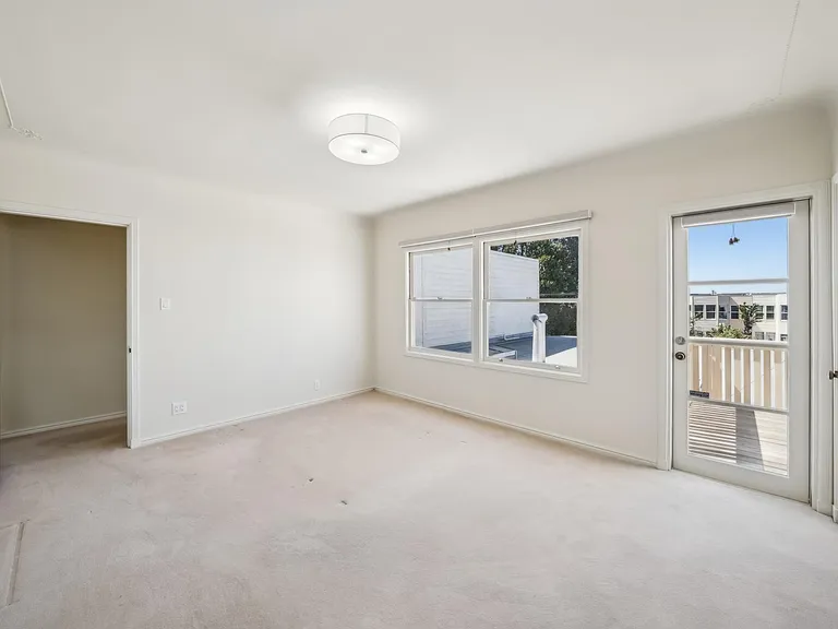 4th bedroom with deck (upper level). ALL CARPET HAS BEEN REMOVED (Hardwood floor are present)
