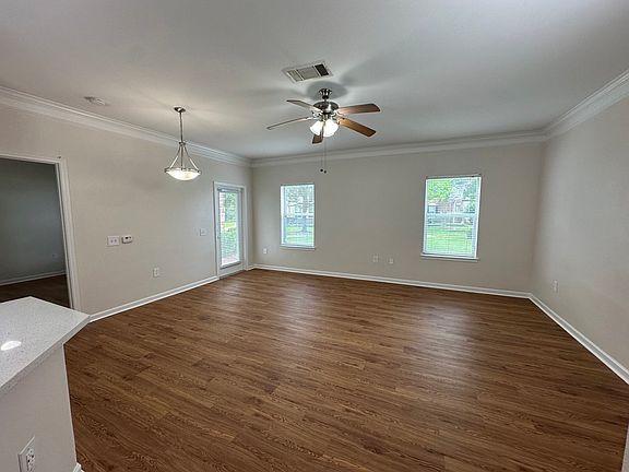 Spacious living area with elegant wood-style floors, large windows, and modern lighting in an inviting open-concept layout. Spacious living area with elegant wood-style floors, large windows, and modern lighting in an inviting open-concept layout.