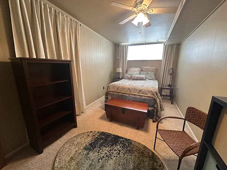Bedroom with storage and room darkening curtains.