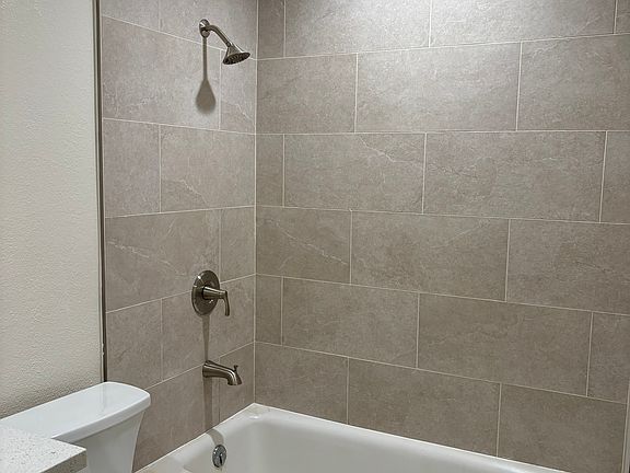 bathroom with new tile, fixtures, vanity and toilet