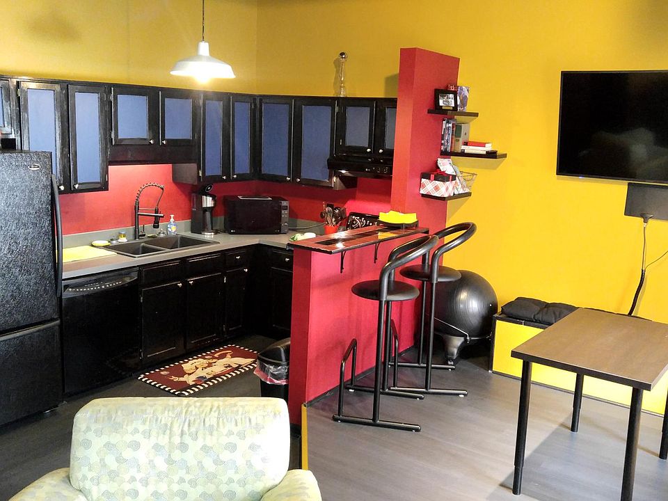 Generous kitchen hugged by new bar with seating for two