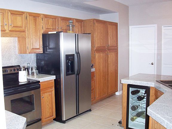 Kitchen with stainless steel appliances, washer/dryer and wine fridge.