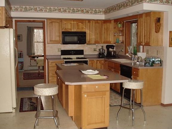 Kitchen with center island, pantry, and adjacent dining and family rooms.