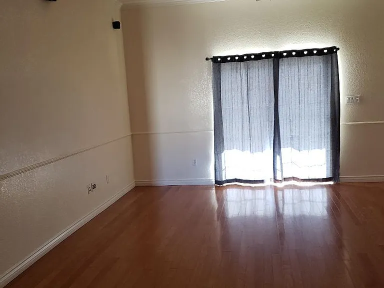 Living Room. Speakers mounted on walls for surround sound. Sliding Window provides access to back yard with room for barbeques and entertainment.