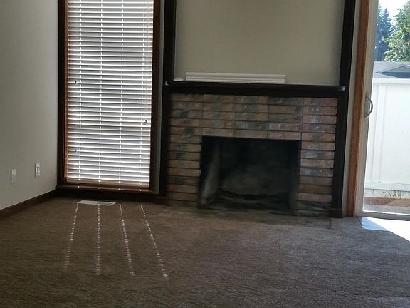 Open Living Room with fireplace and sliding door to patio