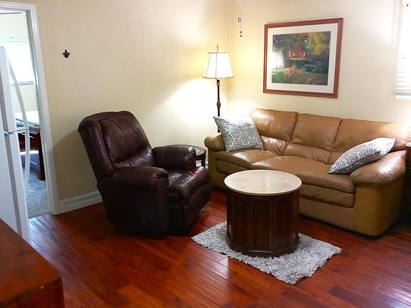 Living room with corner desk, large refrigerator and very comfortable furniture with rocker/recliner chair.