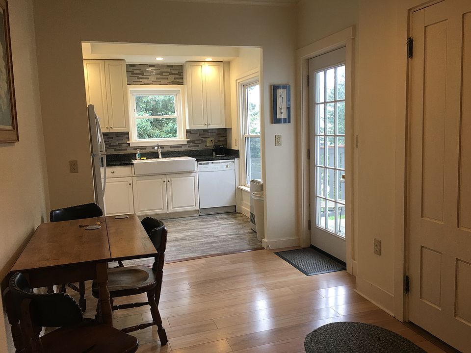 Bright fully equipped eat-in kitchen includes dishwasher, microwave and balcony with sitting area and bistro table and chairs.