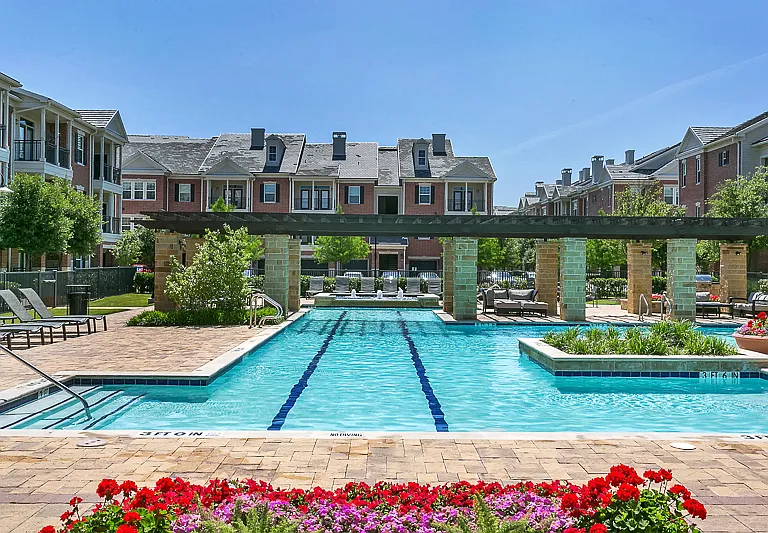 Resort style swimming pool surrounded by beautiful landscaping
