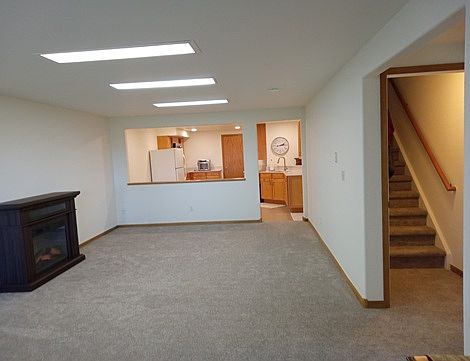Stairs from main entry to living room w/fireplace and eat-in kitchen