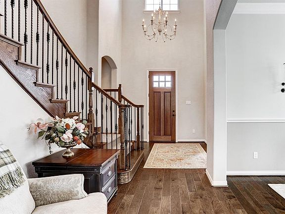 A light and bright entry with a beautiful wood and glass door, custom chandelier, high ceilings, gleaming hardwoods lead you into this stunning home. The hallway to the left leads to the second downstairs bedroom and bathroom.