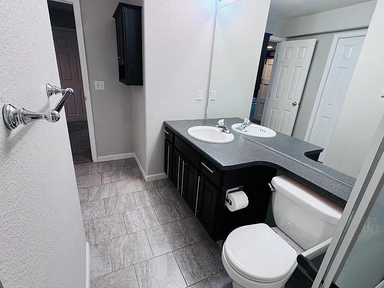 Bathroom with walk-in shower, pocket-door access to Bedroom 1, and a separate entrance from the main apartment