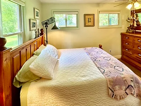 Three windows provide plenty of sunlight to this comfortable bedroom, presenting a new queen sized eco mattress and a recycled pine bedframe and chest of drawers from Australia.