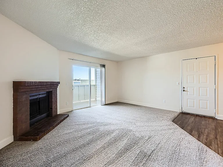 Experience warmth and style in this spacious living room, complete with a fireplace and balcony access.