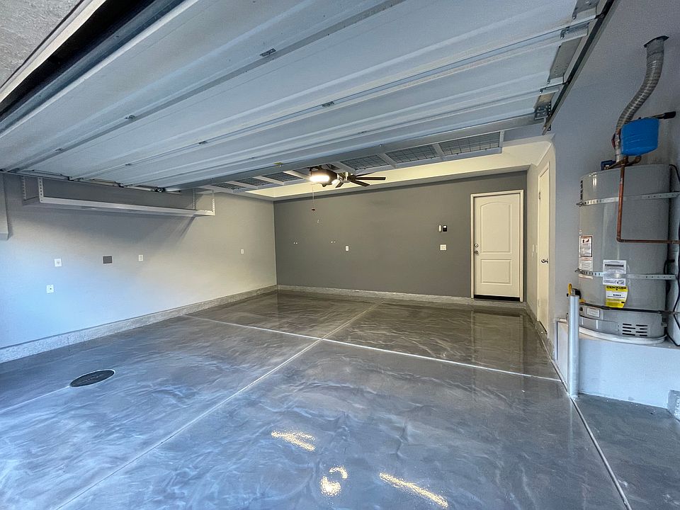 2-car Garage with epoxy floor, storage racks, and ceiling fan.