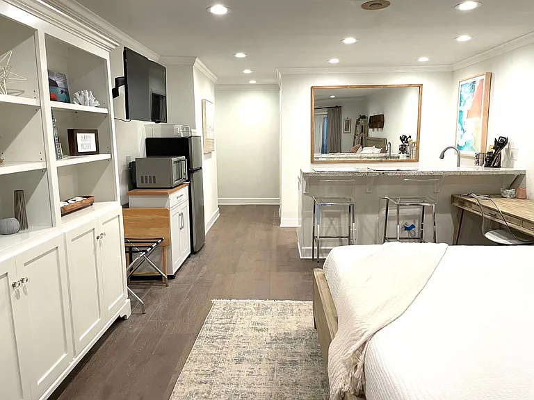 view with storage cabinet on left and seating area with barstools on right
