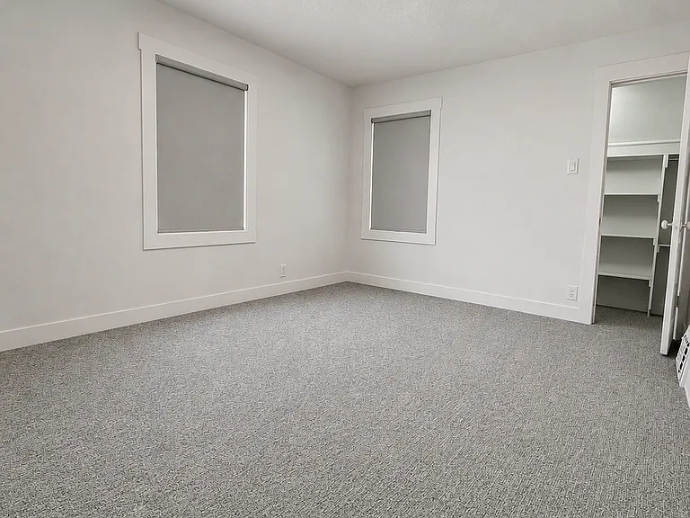 Spacious primary bedroom with plush carpeting and a large walk-in closet.