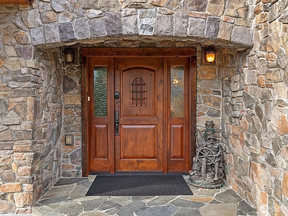 Stunning custom stone entry with slate floor and solid wood front door.>