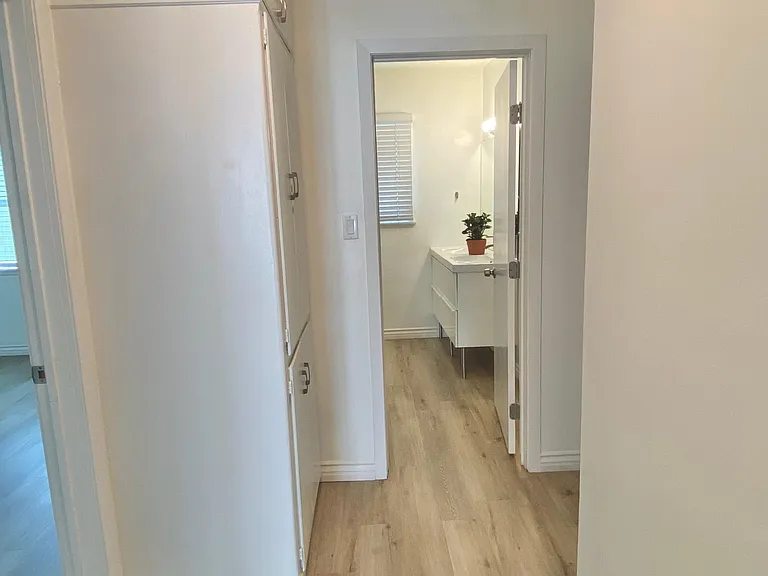 Hallway with a huge floor-to-ceiling storage cabinet.