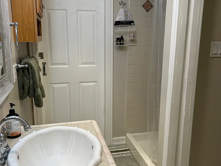 Bathroom with shower and locking pocket door to laundry room.