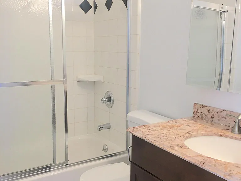 Full bathroom with mirrored medicine cabinet and granite sink top.