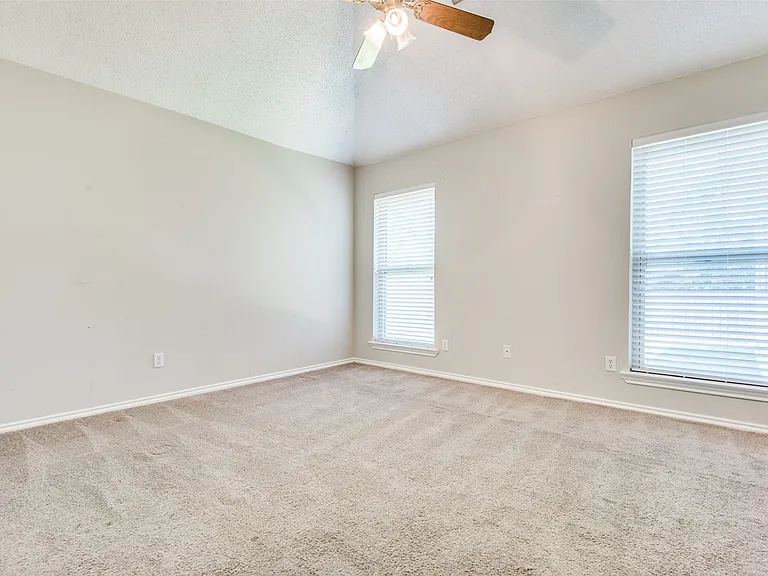 Carpeted room featuring a vaulted ceiling with a ceiling fan