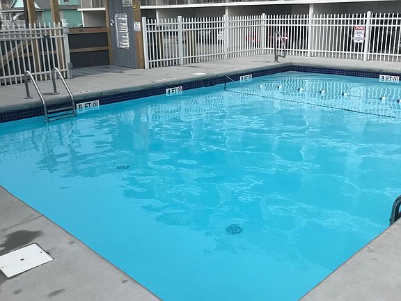 pool with outdoor shower and bathrooms