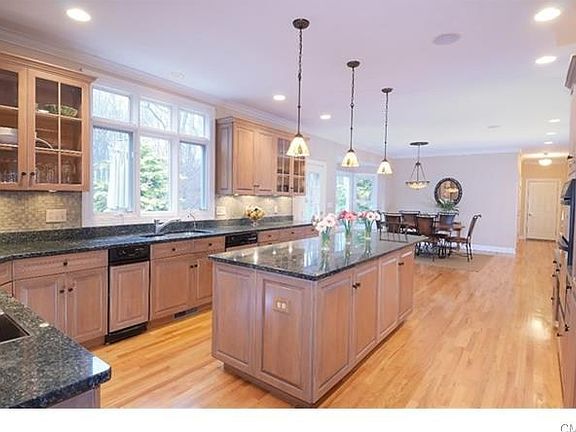 Elegant and simple, the spacious kitchen has wood paneled appliances, granite counters and hw floors.  The garage entry and pantry are nearby.