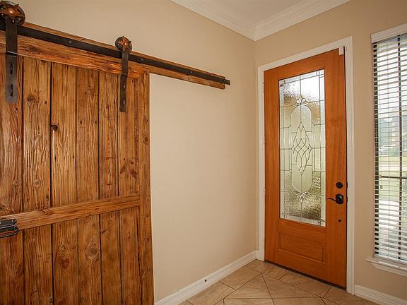 Tile floors and a rustic barn door grace the entry...