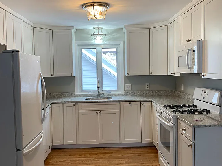 Convenient U shaped white kitchen, quartz counters, hardwood floors throughout the home