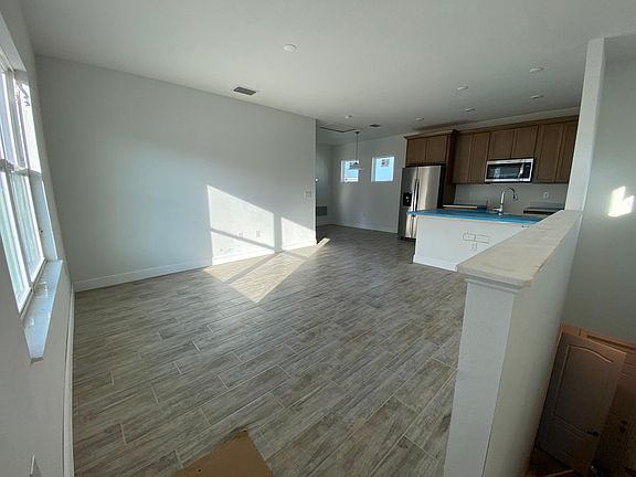 Stairs open up to living area, open concept kitchen/dinning