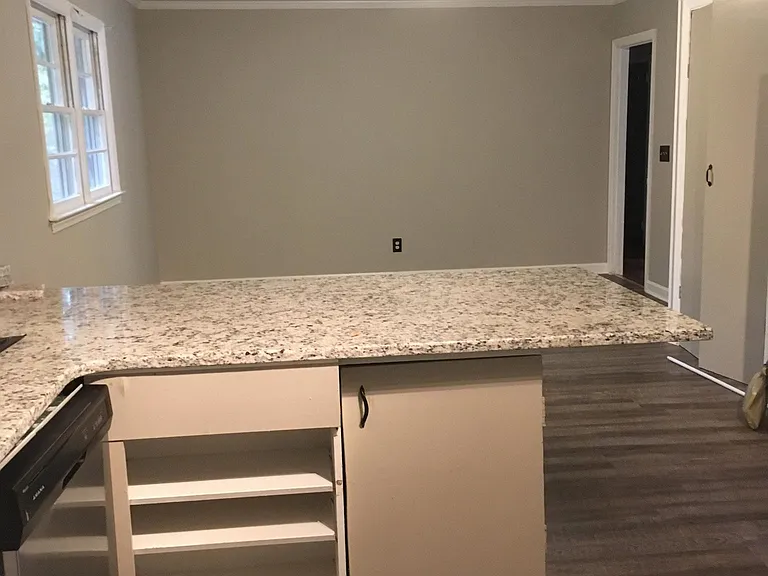 kitchen looking into family room. Granite and stainless-steel appliances.