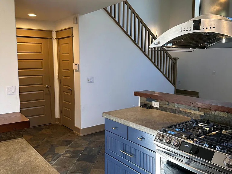 View from kitchen sink looking towards garage, storage door and stairs