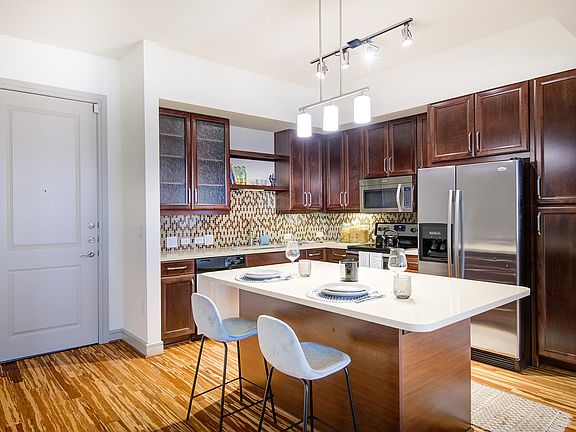 Griffis Uptown apartment kitchen with wood style floors and stainless steel appliances.