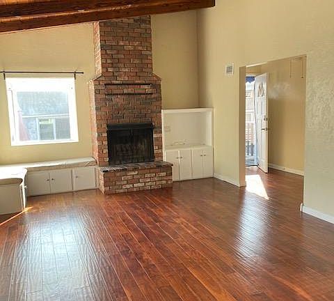 Living room, front bay window with ocean view, fireplace, beam ceiling and built-ins