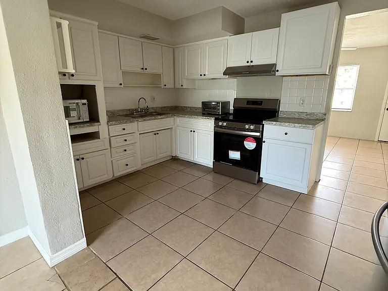 Kitchen comes with a stove that is about a year old and a microwave
