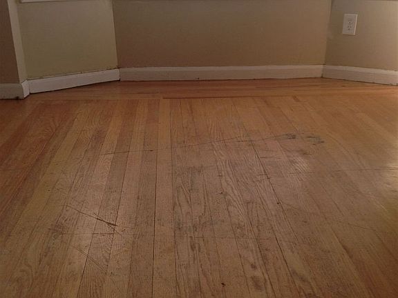 hardwood floor in living room with lots of windows. New Bli