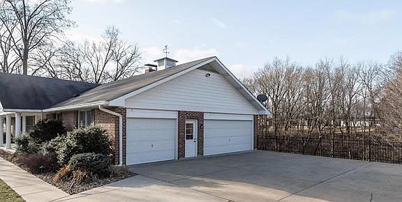 3 Car Side Entry Garage, Finished inside with storage and workshop. Service door to exterior and extra lighting inside.