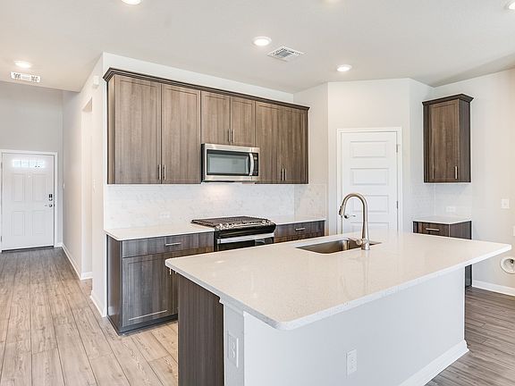 This kitchen features slate-colored cabinets and quartz countertops.