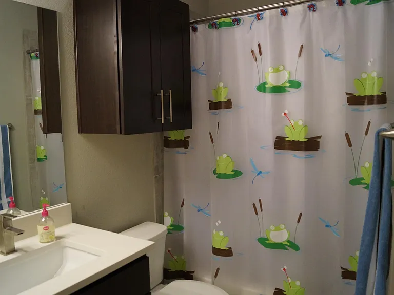 Upstairs full bathroom (view #2). Stone countertops and elongated toilet