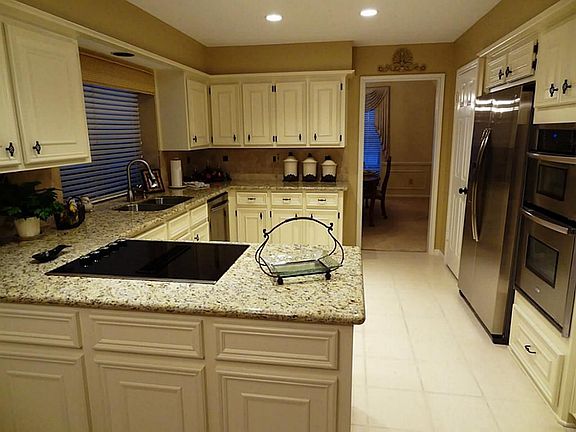 Remodeled kitchen with granite countertops stainless steel appliances, tile flooring and backsplash.