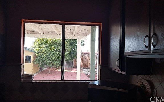 Big kitchen window overlooks beautiful full-grown fruit trees.