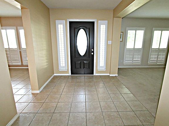 OPEN THE DOOR TO THE ENTRY WITH TILE FLOORS AND PLANTATION SHUTTERS