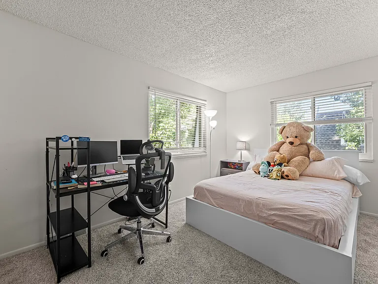 Bright primary bedroom featuring two southeast-facing windows that fill the space with natural light, along with a spacious closet for ample storage.