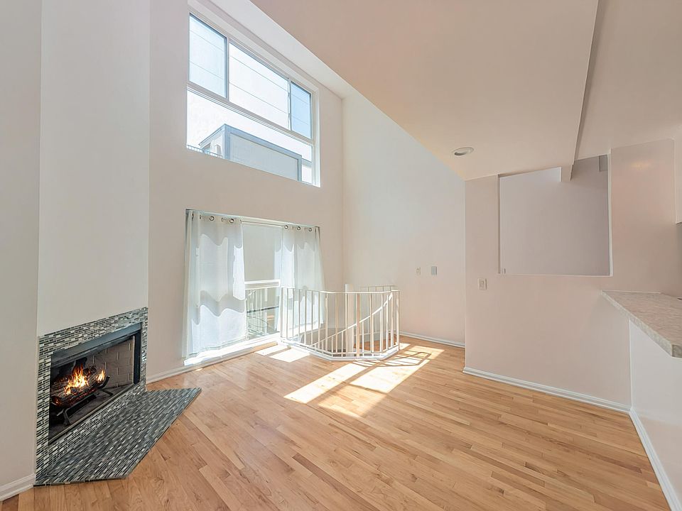 dining area with 3 story height ceiling, large windows and a fireplace